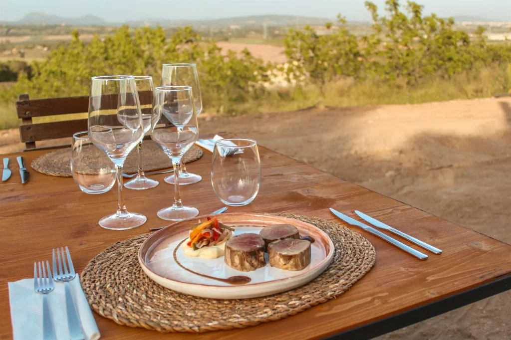 A table set at sunset overlooking Mallorca's agricultural landscape