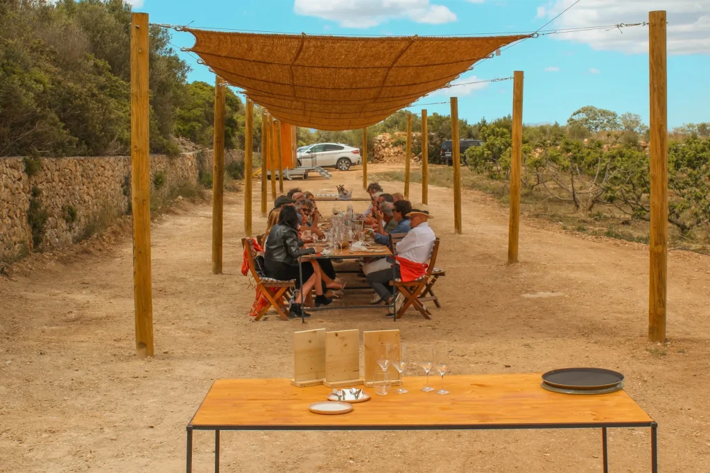 A group of diners at a long table in a rural setting in Mallorca